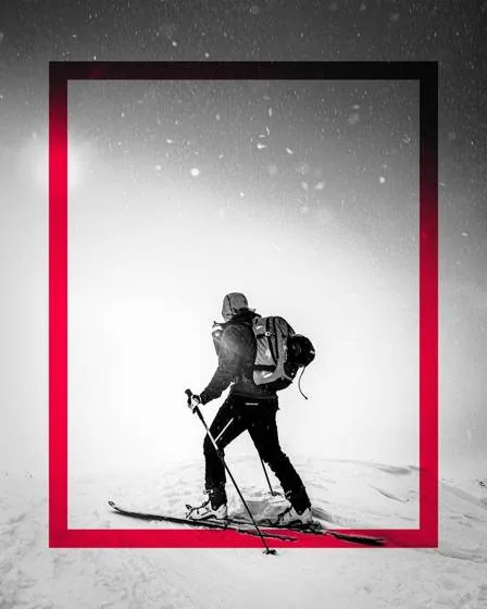 Ski tourer walking through a snowstorm inside a red frame