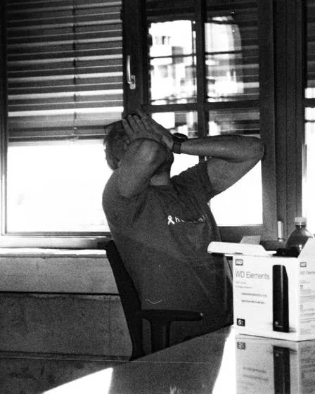 Man at a desk with his hands on his head